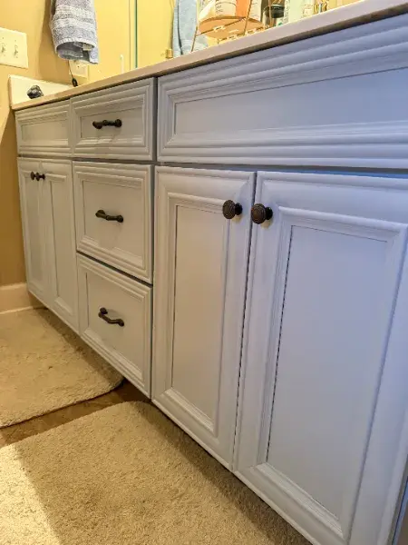 Bathroom vanity painted white with oil-rubbed bronze hardware