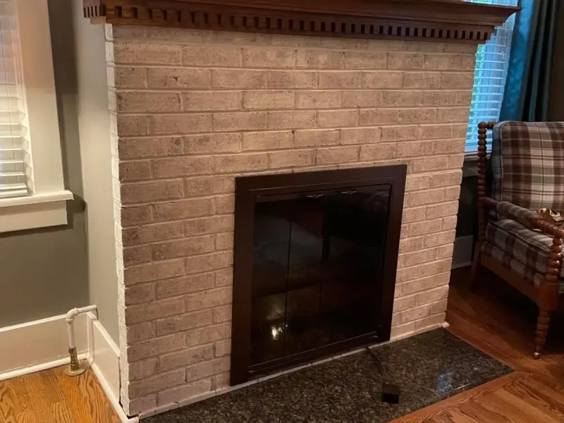 Living room with a white-painted brick fireplace and dark wood mantel