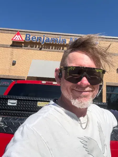 Painter smiling outside a Benjamin Moore paint store
